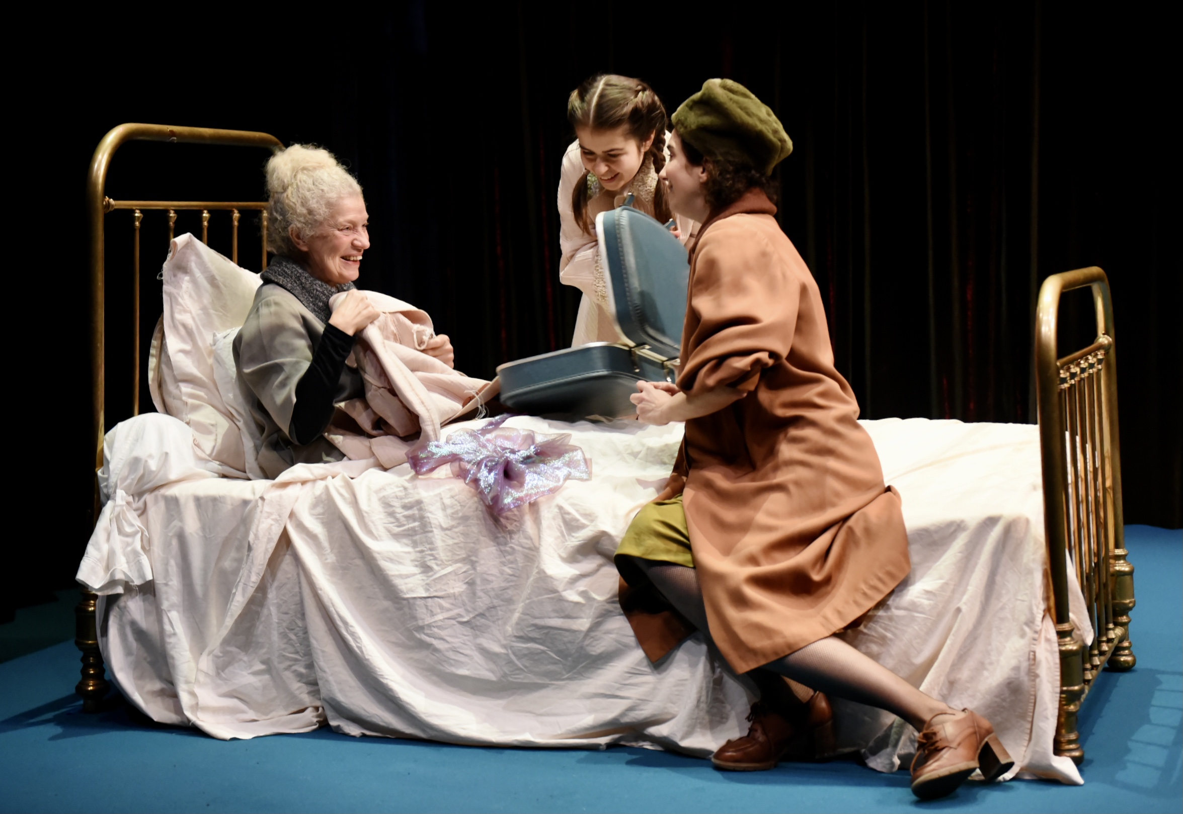 La grand-mère est sur le lit, entourée par la maman et la petite fille. Dans le spectacle "Les Petites bêtes"